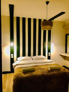 凱里尼亞的住宿－Bohemian Residence，一间卧室配有一张大床,拥有黑白条纹墙