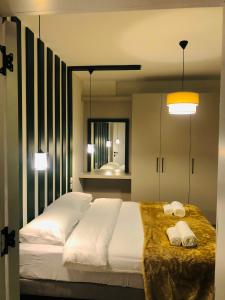 凱里尼亞的住宿－Bohemian Residence，一间卧室配有一张大床和两条毛巾