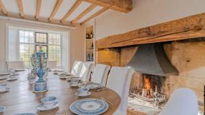 a dining room with a table and a fireplace at Foxholme Manor in Broadway