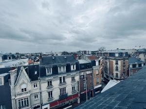 Una vista de una ciudad desde el tejado de un edificio. en Le Sacré, Au pied de la cathédrale, en Reims