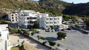 a large white apartment building with a parking lot at Faliraki Dream Apartment 3 in Kallithea Rhodes