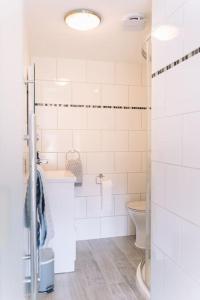 uma casa de banho branca com um WC e um lavatório em Contemporary mid-terrace cottage em Priors Marston