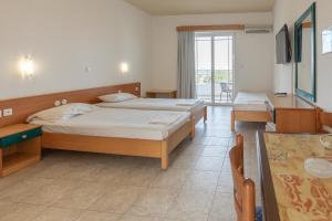 a hotel room with two beds and a table at Faliraki Dream Apartment 3 in Kallithea Rhodes