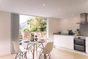 uma cozinha e sala de jantar com mesa e cadeiras em Contemporary mid-terrace cottage em Priors Marston