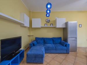 een woonkamer met een blauwe bank en een tv bij Youhosty - Paul Valery 3 in Milaan