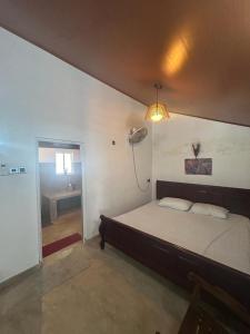 een slaapkamer met een bed en een lampje aan de muur bij LOHAS Villa Hiriketiya in Dikwella