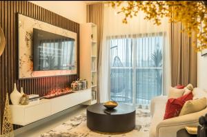 een woonkamer met een bank, een tafel en een spiegel bij Autumn Falls, 2 Bedroom full service equipped appartement in Dubai