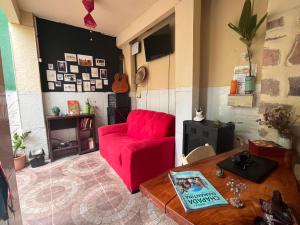 sala de estar con sofá rojo y mesa en Hospedaria Além das Trilhas en Lençóis