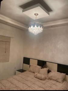 a bedroom with a bed and a chandelier at Apartment in Amman 7th circle in Amman