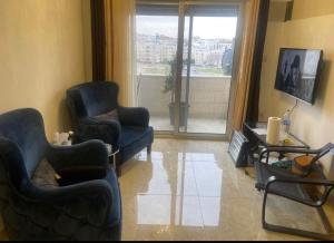 安曼的住宿－Apartment in Amman 7th circle，客厅配有两把椅子和电视