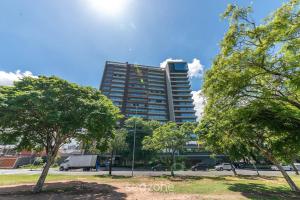 a tall building with trees in front of it at AIR - Apartamentos bem localizados em Porto Alegre/RS in Porto Alegre