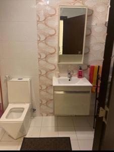 a bathroom with a toilet and a sink and a mirror at Apartment in Amman 7th circle in Amman