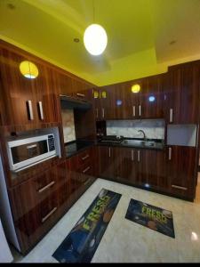 a kitchen with wooden cabinets and a microwave at Apartment in Amman 7th circle in Amman
