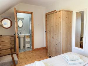 a bedroom with a bed and a sink and a mirror at Inish Holiday Cottage in Kilmore Quay
