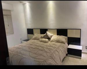 安曼的住宿－Apartment in Amman 7th circle，一间卧室配有一张大床和木制床头板