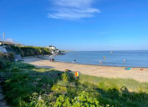 a beach with people playing in the water at Inish Holiday Cottage Kilmore by Trident Holiday Homes in Kilmore Quay +6 photos