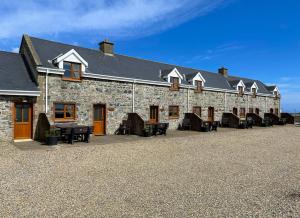 a stone building with benches and tables in front of it at Inish Holiday Cottage Kilmore by Trident Holiday Homes in Kilmore Quay