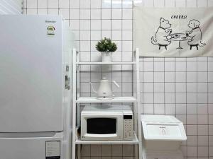 a kitchen with a microwave on a shelf next to a refrigerator at Seoul center new Sindang station in Seoul