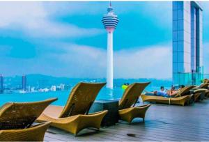 un grupo de sillas en una terraza con vistas a la aguja espacial en The platinum suites Kuala lampur heaven touch, en Kuala Lumpur