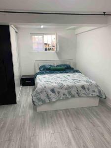 um quarto com uma cama e piso em madeira em Charmant logement parking gratuit, gare proximité em Sevran