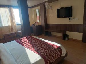 a hotel room with a bed and a flat screen tv at zoz Sm1 in Shimla