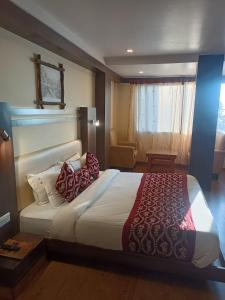 a bedroom with a large bed with red pillows at zoz Sm1 in Shimla