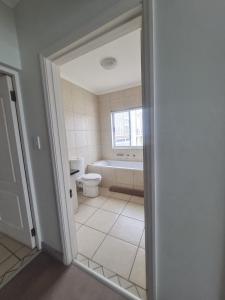 a bathroom with a tub and a toilet and a window at Point Village Accommodation - Stephen in Mossel Bay
