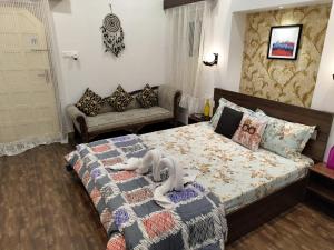 een slaapkamer met een bed en een bank bij Leisure Homestay in Udaipur