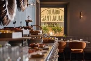 a restaurant with tables and chairs with food on them at Sant Jaume Design Hotel in Palma de Mallorca