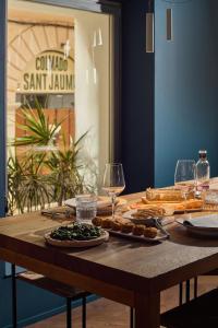 a wooden table with wine glasses and food on it at Sant Jaume Design Hotel in Palma de Mallorca