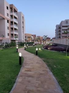 a pathway in a park with lights in the grass at Stylish 3 bedroom apartment close to the Pyramids and Grand Egyptian Museum in ‘Ezbet `Abd el-Ḥamîd +22 photos