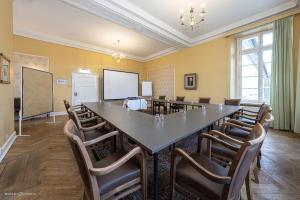 a conference room with a large table and chairs at Schlosshotel Westerholt in Herten
