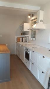a white kitchen with white cabinets and a stove top oven at Villa Arbatica in Barbat na Rabu
