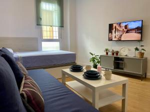a living room with a couch and a table at Nuevo estudio junto al Guadalquivir in Seville