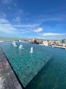 a large pool of water on top of a building at Lindos Flats Studios no Qualité in Tambaú