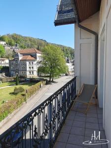 a balcony with a bench and a view of a street at L appartement du chalet rose in Plombières-les-Bains