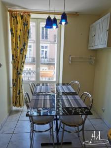 a dining room with two tables and chairs and a window at L appartement du chalet rose in Plombières-les-Bains