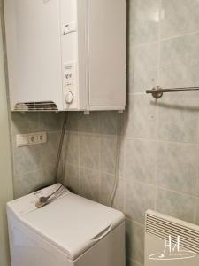 a small bathroom with a white cabinet above a toilet at L appartement du chalet rose in Plombières-les-Bains