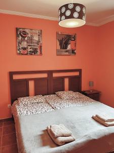 um quarto com paredes cor de laranja e uma cama com 2 toalhas em Bungalow with 2 bedrooms, Playa la Tejita em El Médano