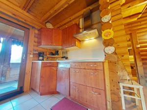 a kitchen with wooden cabinets in a wooden cabin at Au chalet de La Burotte in Basse-sur-le-Rupt