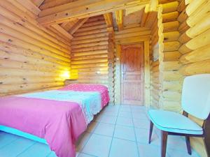 a bedroom with a bed in a log cabin at Au chalet de La Burotte in Basse-sur-le-Rupt