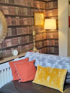 une chambre avec un canapé et un mur de livres dans l'établissement Shakespeare, à Measham