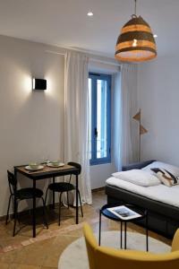 Habitación pequeña con cama, mesa y sillas en Charmant studio à deux pas de Monaco, en Beausoleil