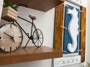 Una bicicleta en un estante con un reloj. en Mar & Descanso Itaparica, en Vila Velha