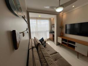 Mar & Descanso Itaparica في فيلا فيلها: غرفة معيشة مع أريكة وتلفزيون بشاشة مسطحة