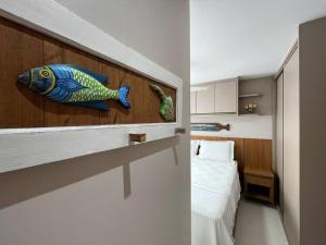 ein Schlafzimmer mit einem Fisch an der Wand neben einem Bett in der Unterkunft Mar & Descanso Itaparica in Vila Velha