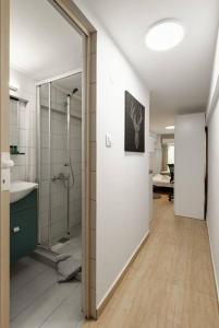 uma casa de banho com um chuveiro, um lavatório e um espelho. em Downtown Studio Thessaloniki em Tessalônica