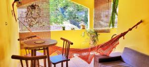 Zimmer mit Hängematte, Tisch und Stuhl in der Unterkunft Casa Sapucaia - Praia in Santa Cruz Cabrália