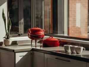 two red pots sitting on a counter next to a sink at Sensiri Myst Country House in Dullstroom