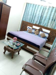 a bedroom with a bed and a table and chairs at Embassy inn Guest House Hyderabad in Hyderabad